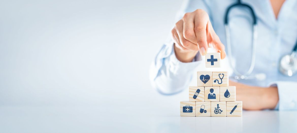 Hand arranging wood block with healthcare medical icon. Health insurance - concept.