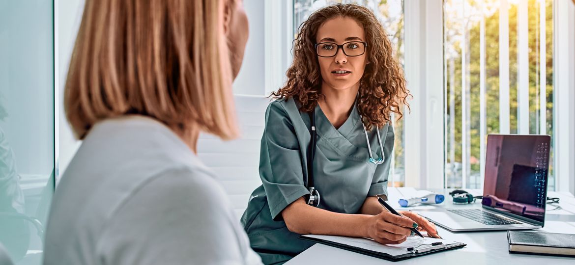 Doctor woman dressed in medical suit talking in office. Reception and consultation with a doctor.